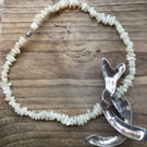 Silver pendant on mother of pearl beads.