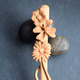 A unique hand carved wooden art spoon featuring relief carving on the handle
