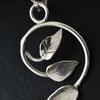 Spiral silver pendant with three leaves