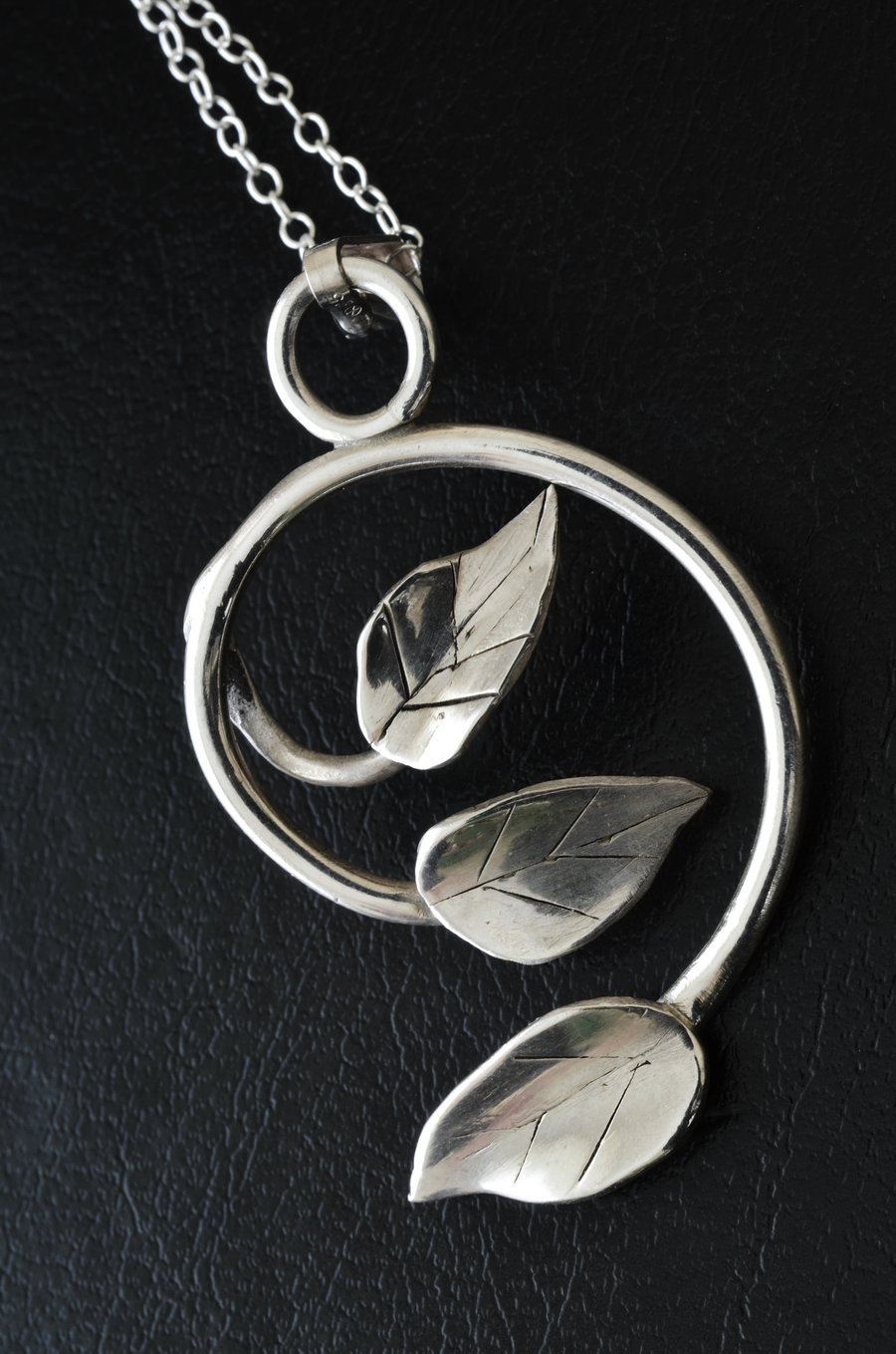 Spiral silver pendant with three leaves