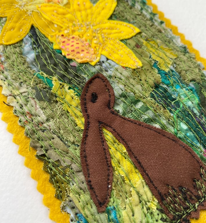Upcycled embroidered spring rabbit and daffodil home decoration. 