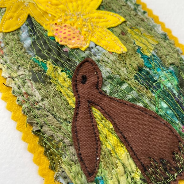 Upcycled embroidered spring rabbit and daffodil home decoration. 