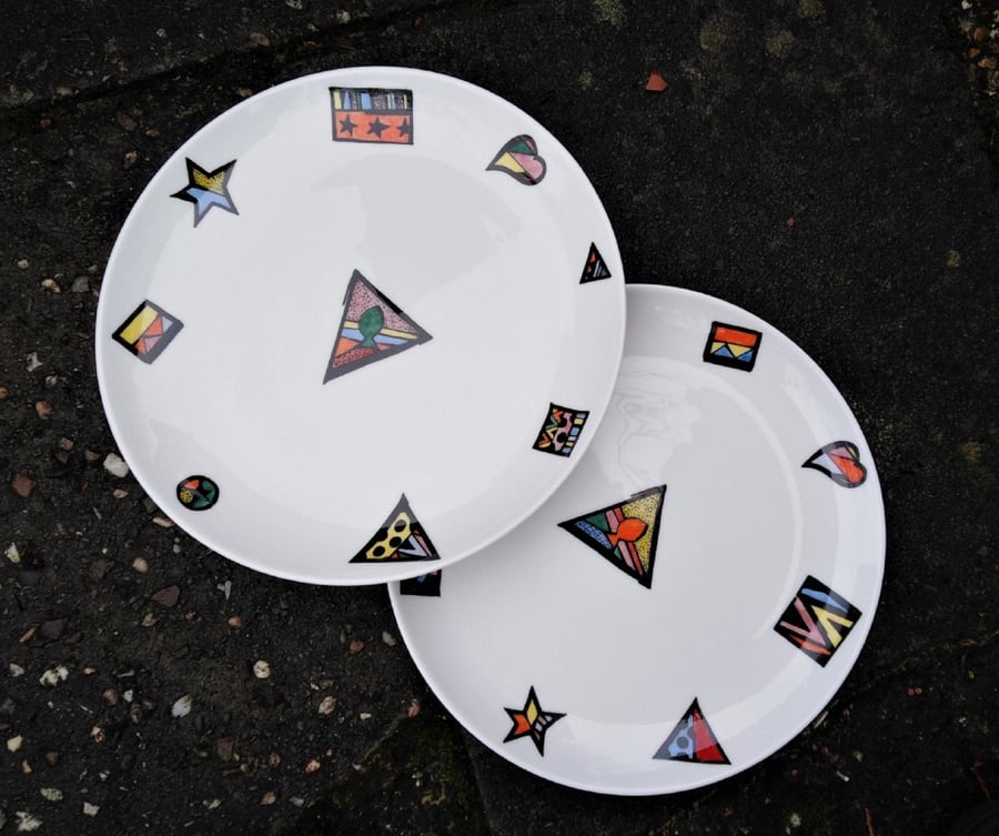 A set of two dinner plates with a colourful abstract pattern, hand decorated.