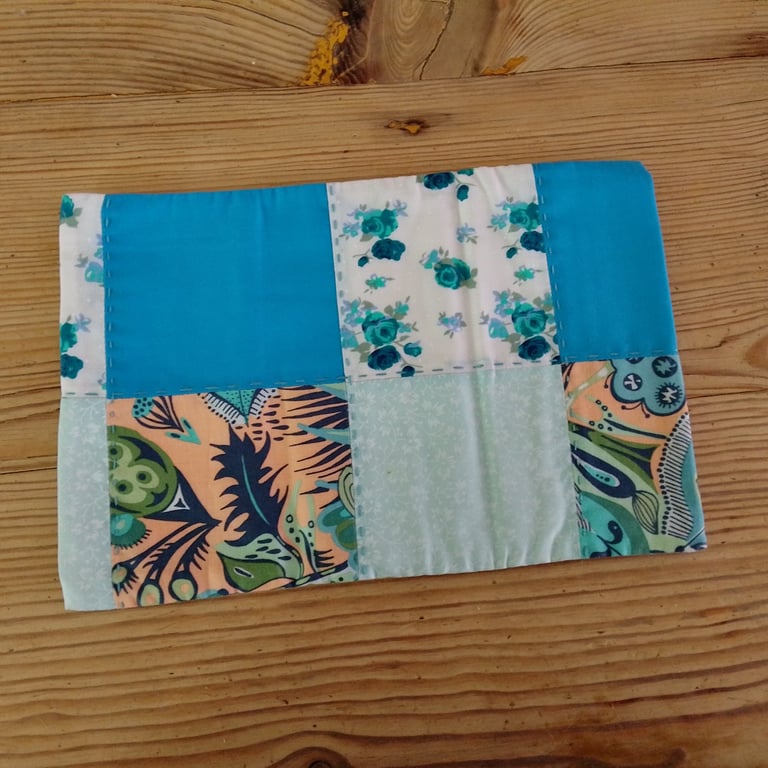 Cushion cover made in a green and blue theme with envelope closure.