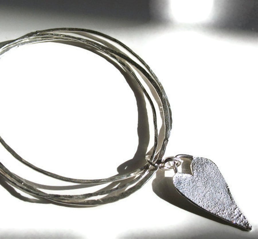 Sterling silver bangle with a heart.