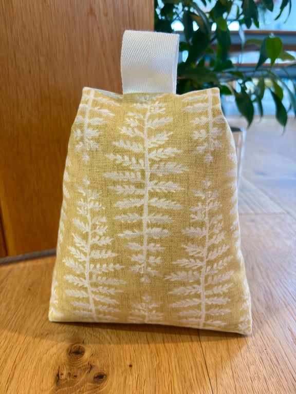 Cotton fabric doorstop in mustard with cream fern print, filled with pebbles