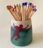 Strike a pose. Ceramic striker pot.