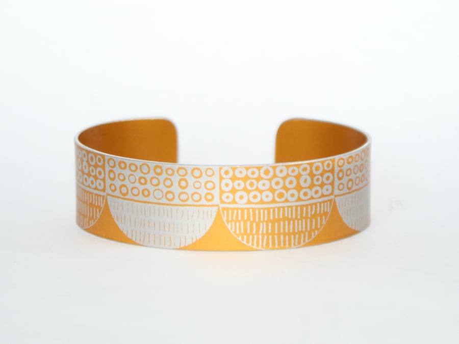 Seed head pattern aluminium cuff orange