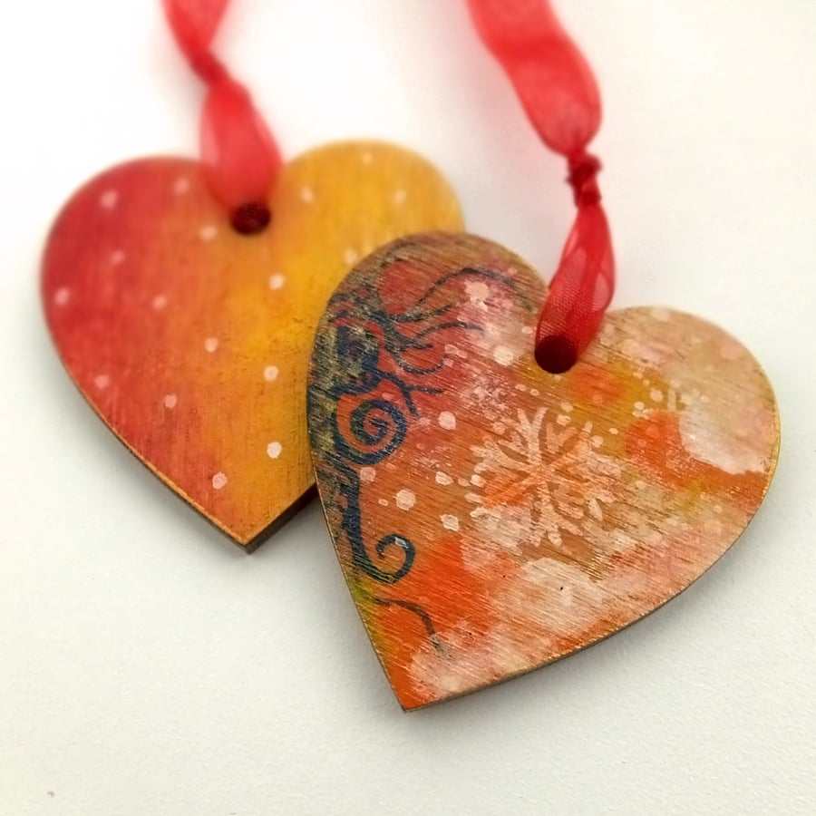 Heart shaped pair of bright handpainted Christmas decorations with snowflakes