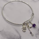 Silver plated charm bangle with clear topaz and amethyst stones 
