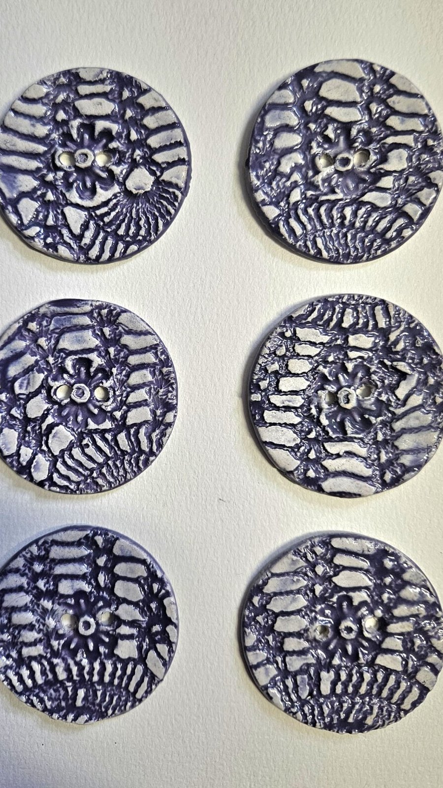 A Set of Six Purple and White Lace Imprint Buttons