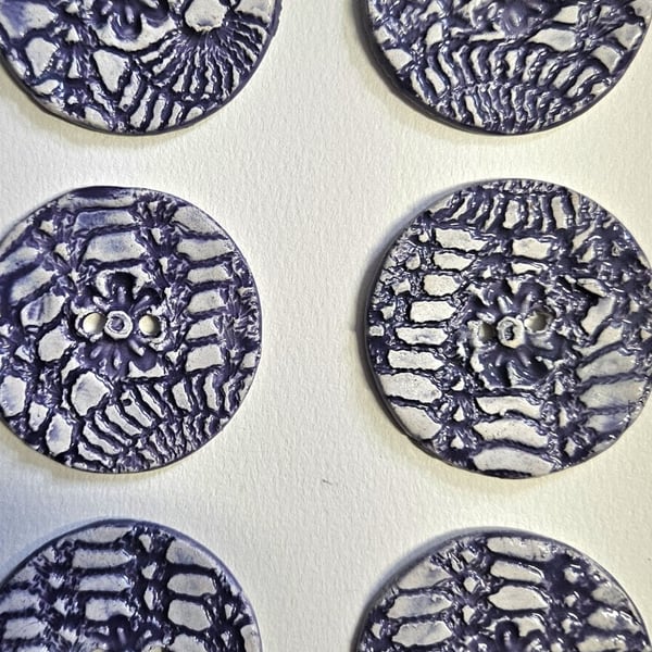 A Set of Six Purple and White Lace Imprint Buttons