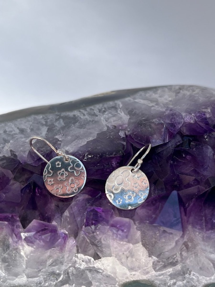 Silver round earrings with flower texture