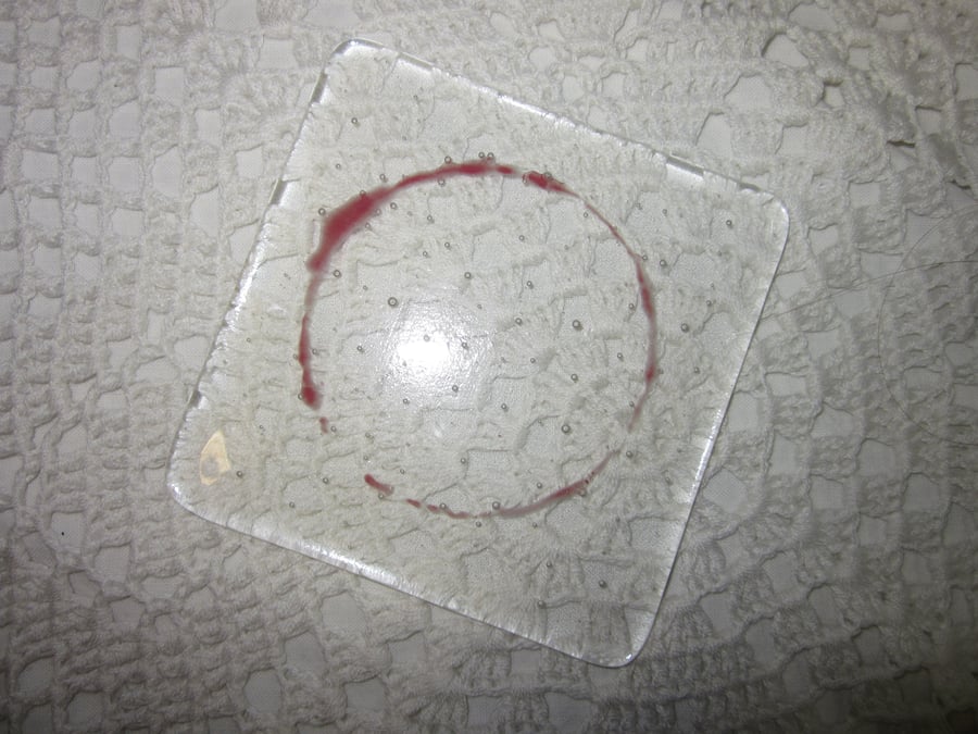 Fused glass coaster, red wine stain on clear
