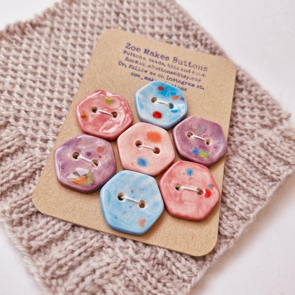 Patchwork flower of pink, purple and blue hexagon buttons.