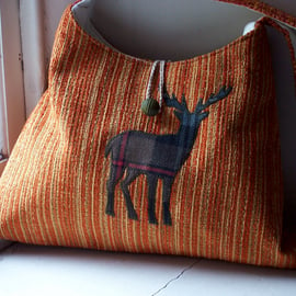 Orange fabric shoulder bag with tartan stag applique on the front