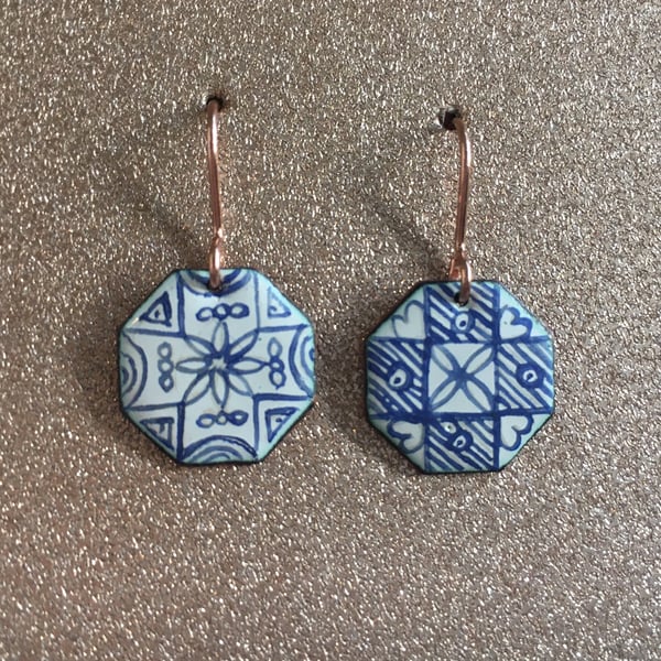 Heaxagonal copper dangle earrings decorated with blue and white enamel
