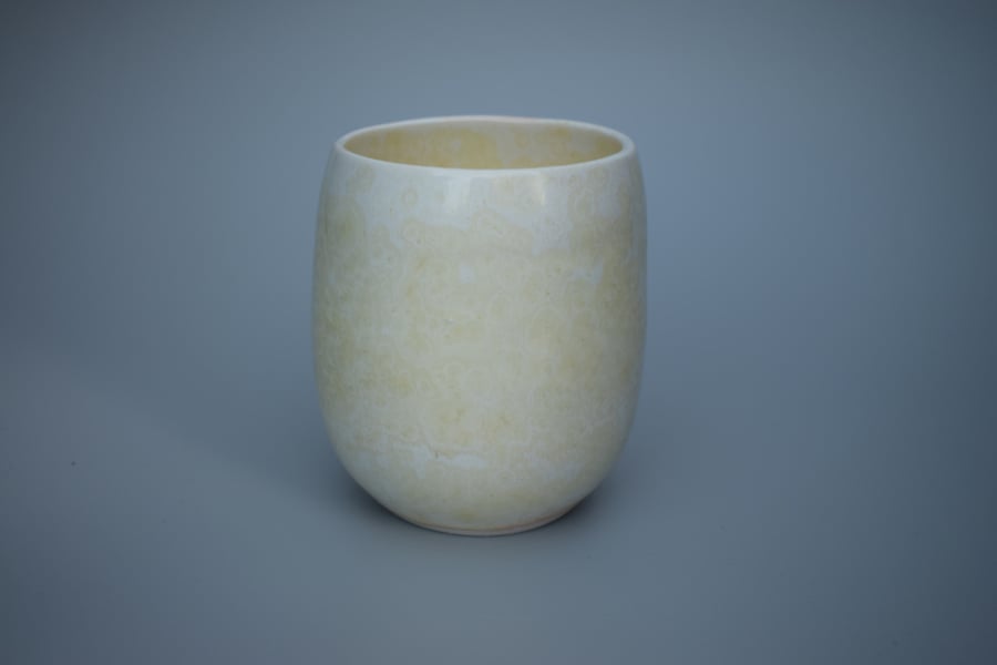 Stoneware teacup, tumbler or beaker in pale yellow with a hint of orange 