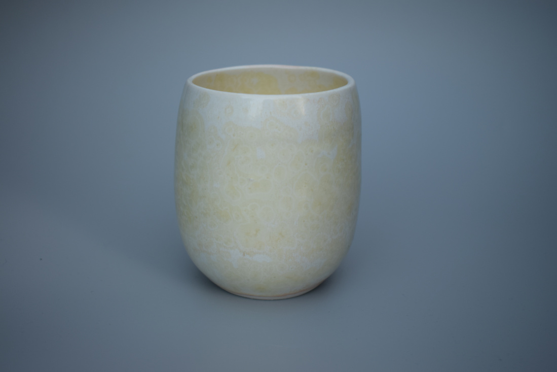 Stoneware teacup, tumbler or beaker in pale yellow with a hint of orange 