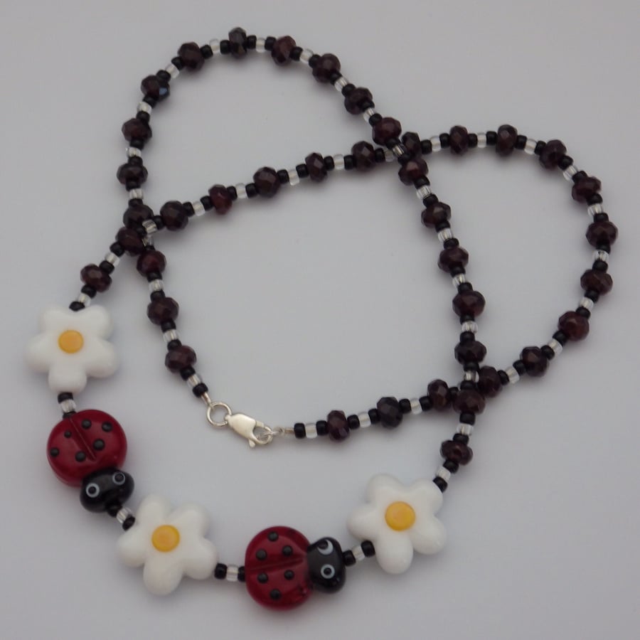 Lampwork glass ladybird and flower bead necklace with faceted garnet beads