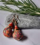 Handmade dangly polymer clay earrings in an orange swirl  design - Image 2