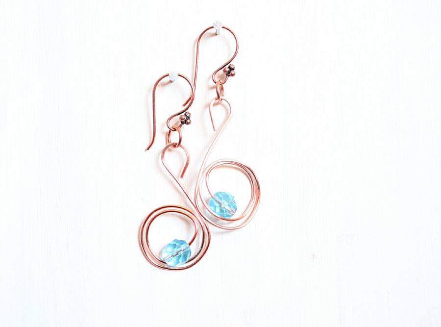 Pale blue faceted glass bead and copper swan spiral dangle earrings