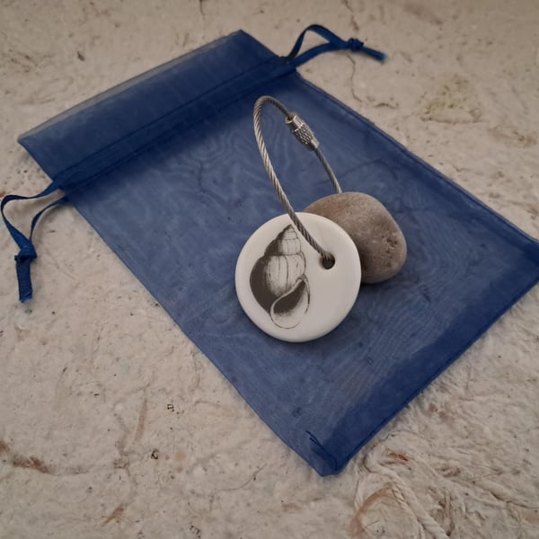 Pebble keyring with a shell image