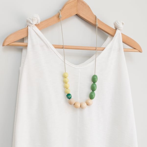 Flori - beaded necklace, olive green, white and yellow with a carved wooden bead
