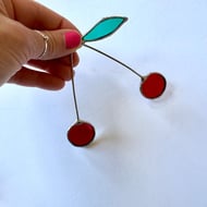 Iridescent deep red stained glass cherry brunch with a single leaf