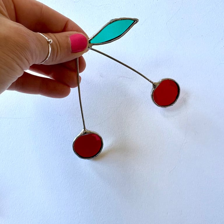 Iridescent deep red stained glass cherry brunch with a single leaf