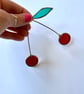 Iridescent deep red stained glass cherry brunch with a single leaf