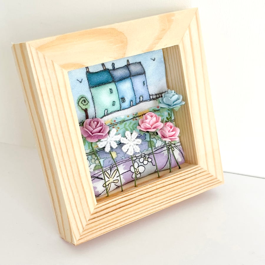 Little blue 3D houses with flowers, in a small frame