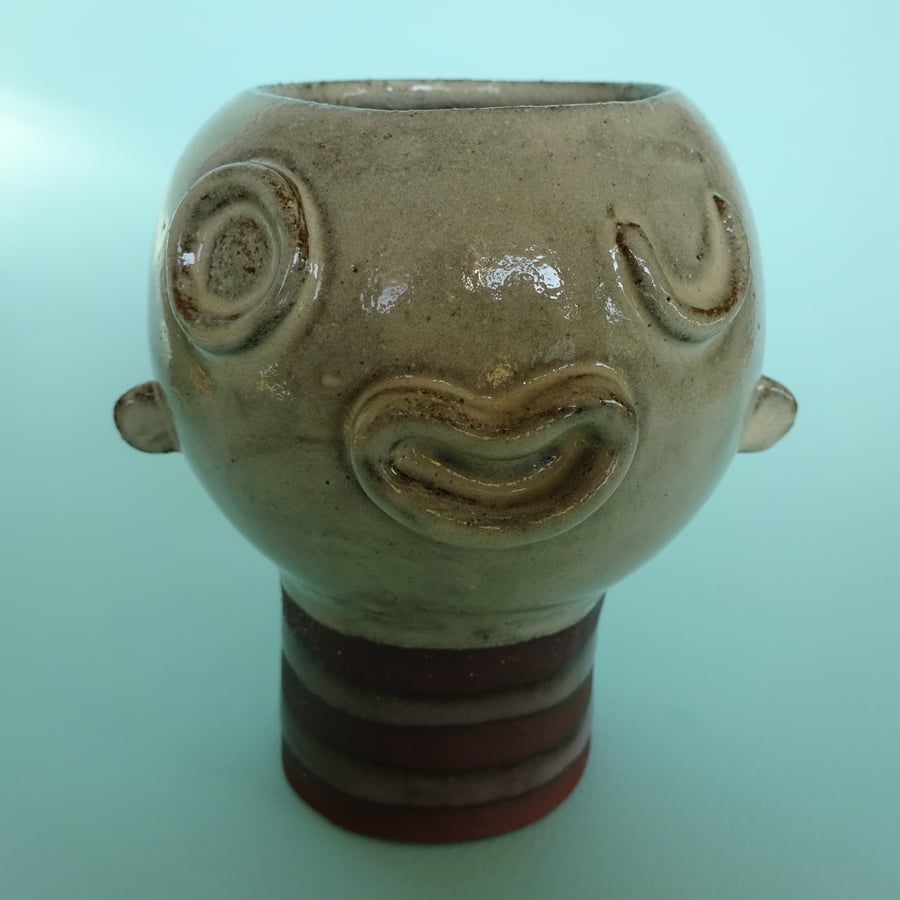 Ceramic face pot with winking eye