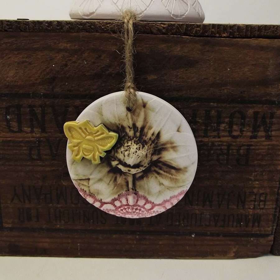 Pottery decoration with natural flower and bee motif.