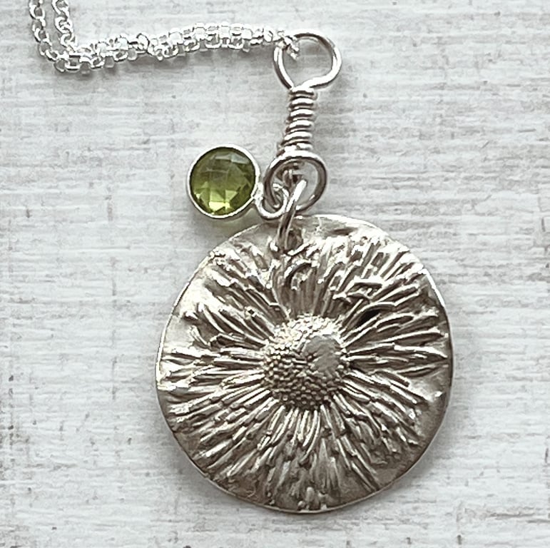 Silver daisy pendant with peridot charm