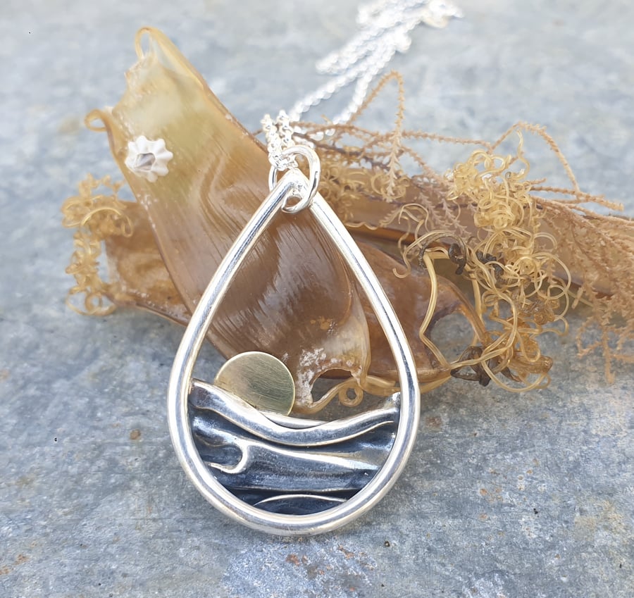 Silver sun rising over sea pendant