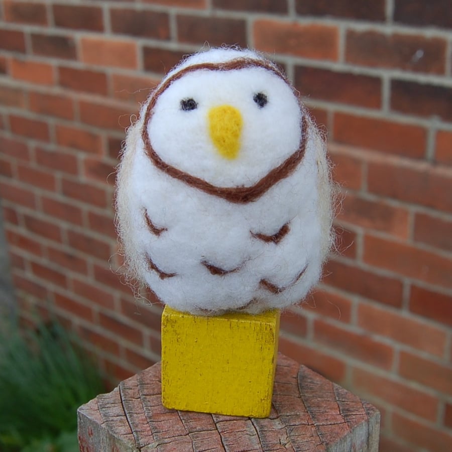 Snowy Owl on a yellow wooden building block