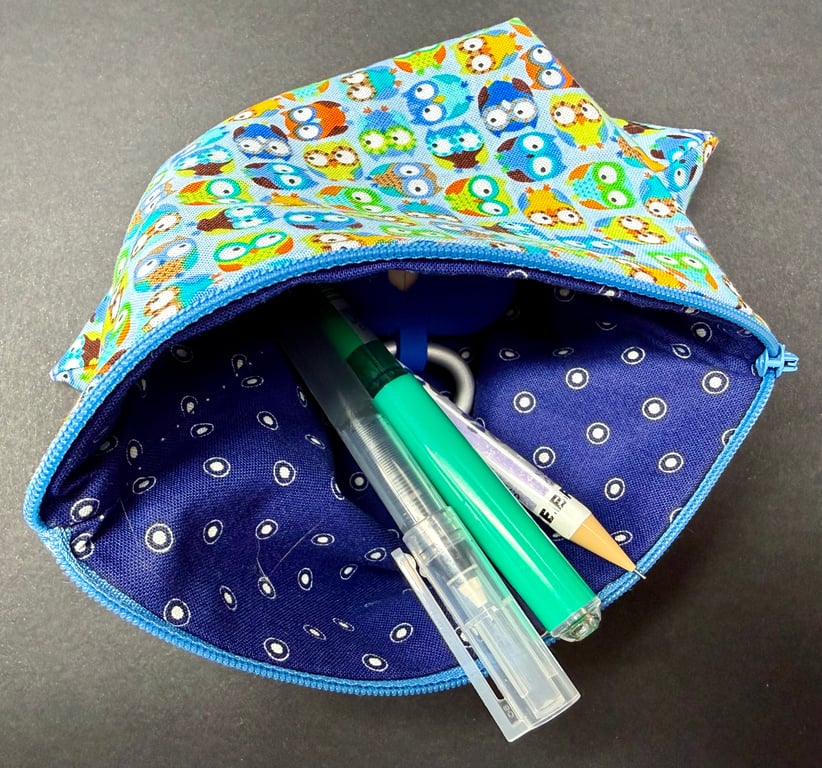 Medium zipped pouch with colourful owls on light blue