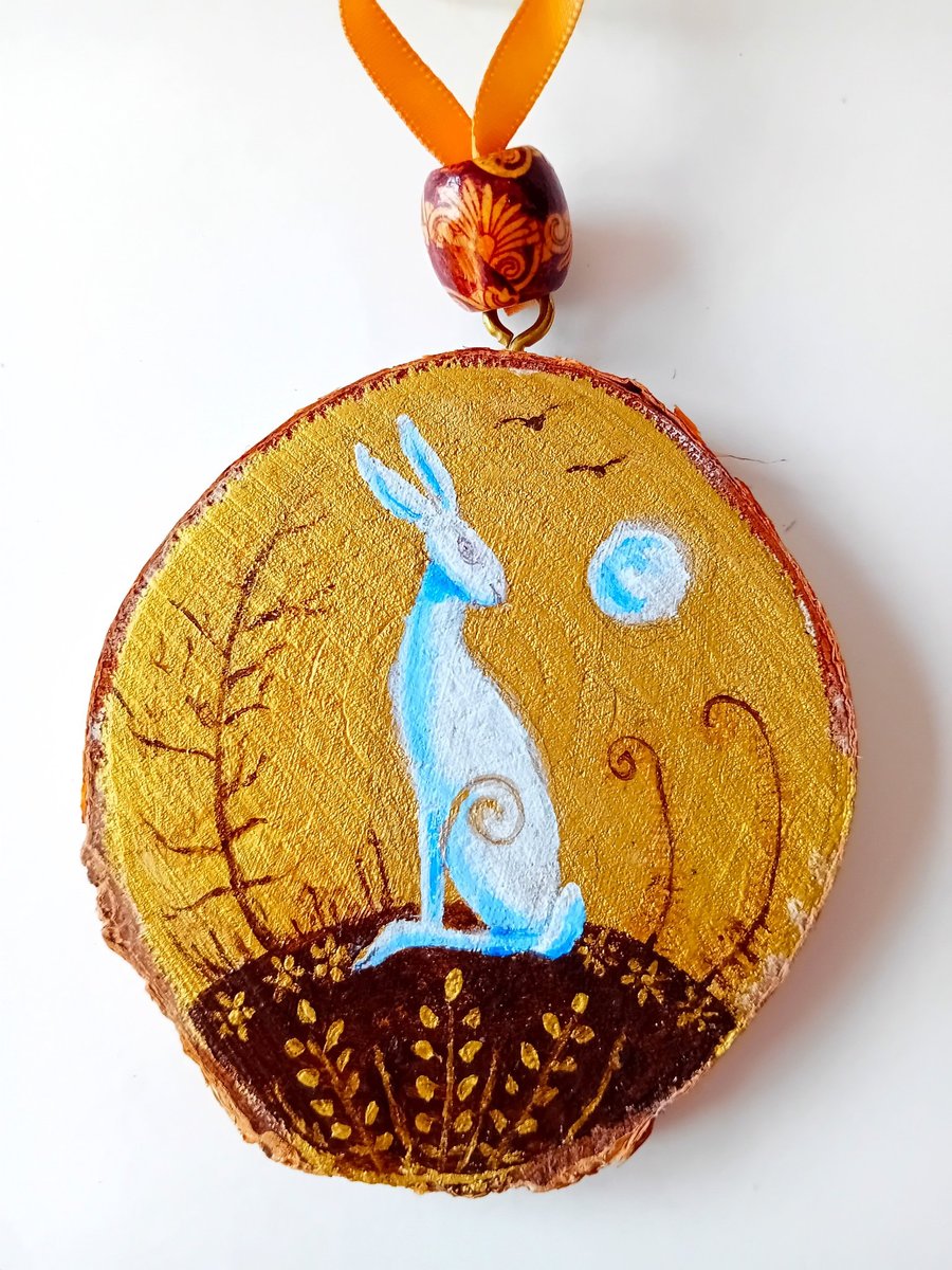 gold wood slice with a white hare