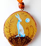 gold wood slice with a white hare