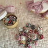 Tiny Box containing 20 Mini Suffolk Puffs (yoyo’s) in lilacs and pinks