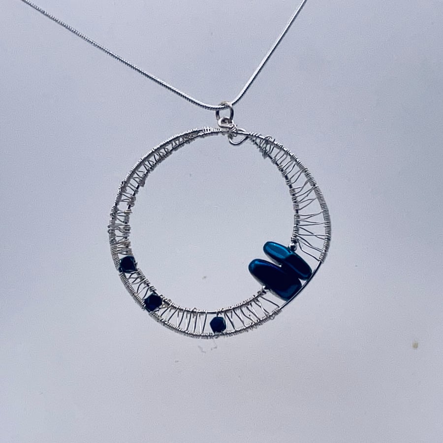 Shimmering midnight blue hematite wire woven wheel pendant