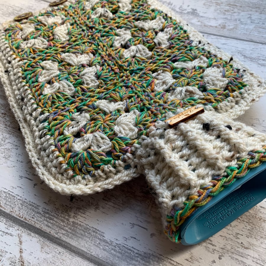 A hot water bottle and handmade crochet cover in tweed and green