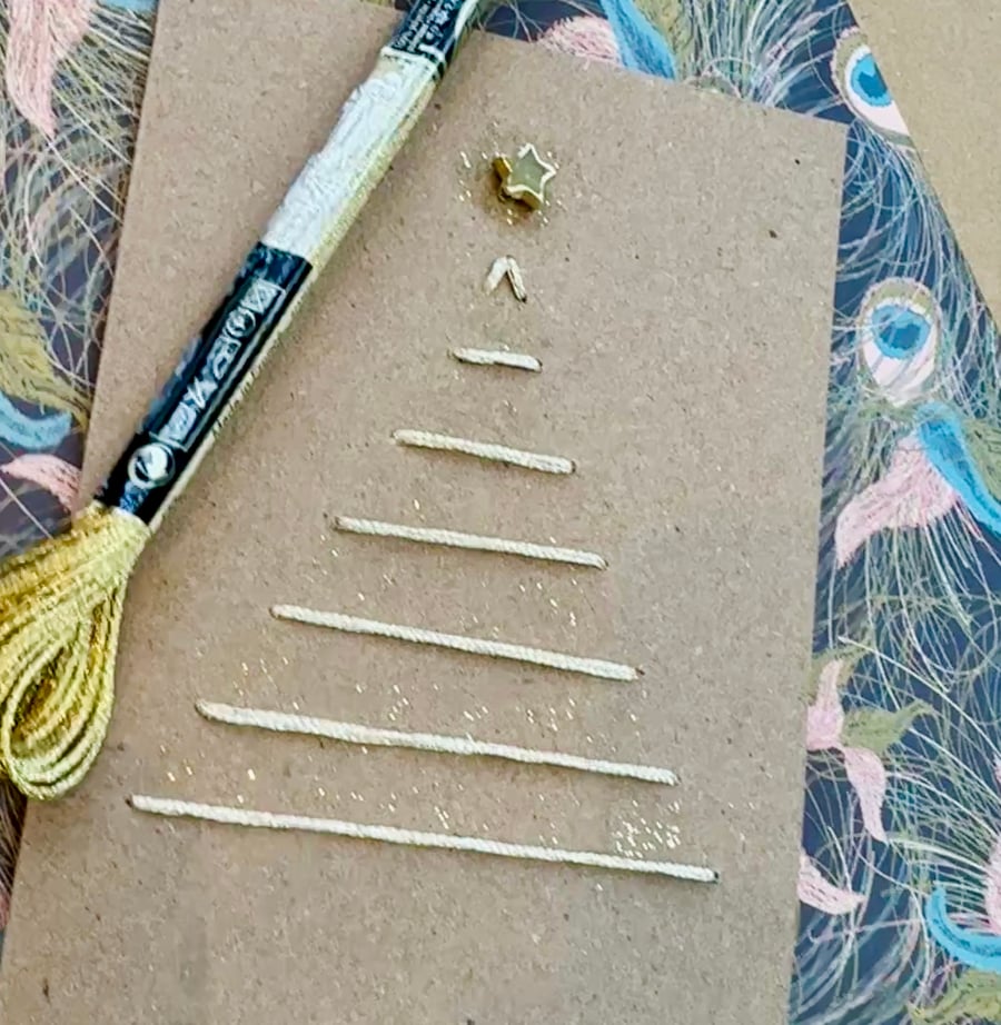 Christmas card of a gold embroidered tree with star, glitter. Natural recycled