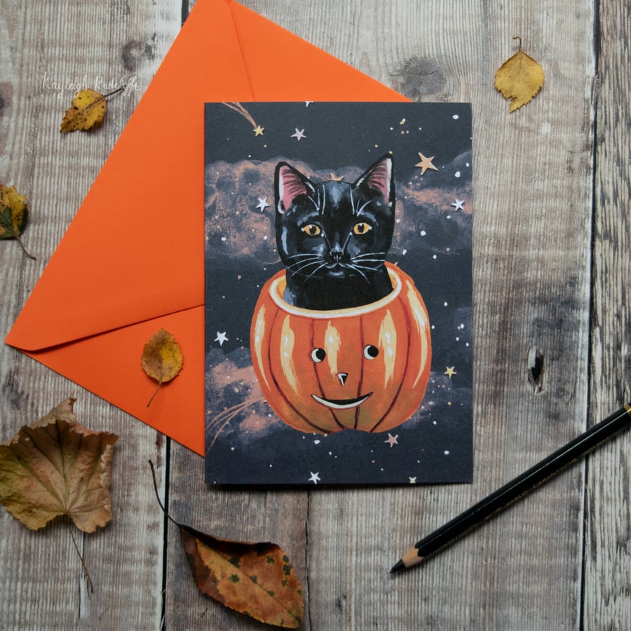 Greeting note card of a black cat in a pumpkin