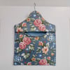Peg bag in blue floral print with a spotted lining.