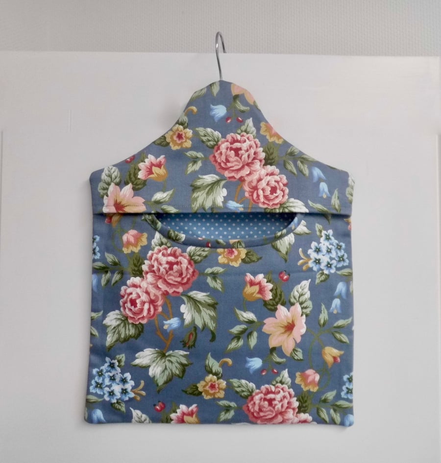 Peg bag in blue floral print with a spotted lining.