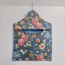 Peg bag in blue floral print with a spotted lining.