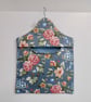 Peg bag in blue floral print with a spotted lining.