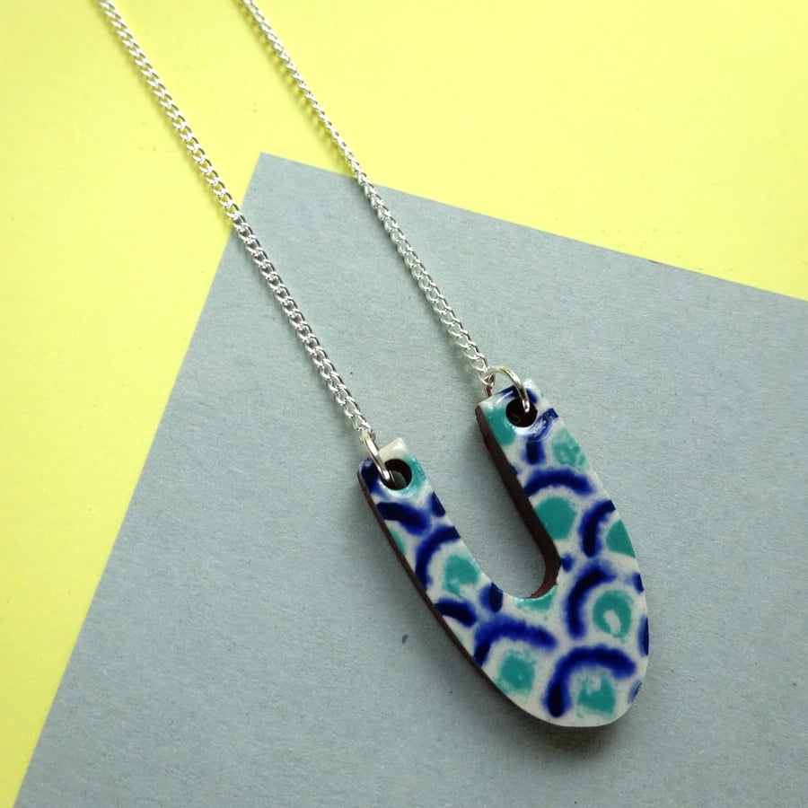 Ceramic U pendant in white, blue and jade on a curb chain necklace